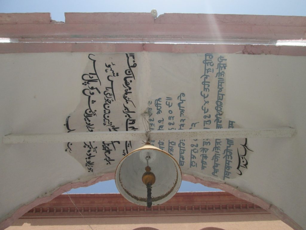 Inscriptions on main entrance gate trefoil arch with holy Bell